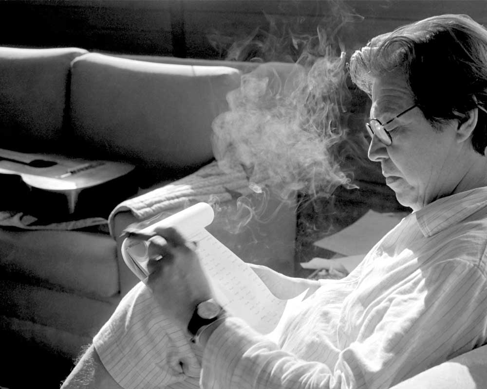 Brazilian composer Antonio Carlos Jobim, smoking a cigar, relaxing at home