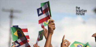 Celebrating Bahia's Independence Day with handheld flags for the state of Bahia and of Brazil.