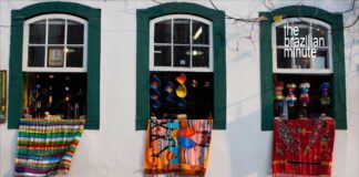 Experience Brazil’s World Heritage Sites. Colorful handmade rugs drape from open windows from the outside of a home in Ouro Preto Brazil.
