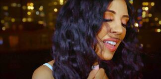 Cecy Santana's video and lyrics capture Sao Paulo's positivity. Brazilian singer performing in front of gold-hued city lights at night.
