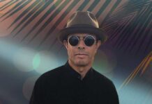 Gregory Abbotts Whisper The Words. The R&B singer wearing trendy sunglasses and stylish hat in front of a tropcial backdrop.