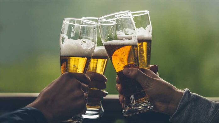 Brazil's craft beer primer. Four men toast with foamy golden ales in clear tall glasses